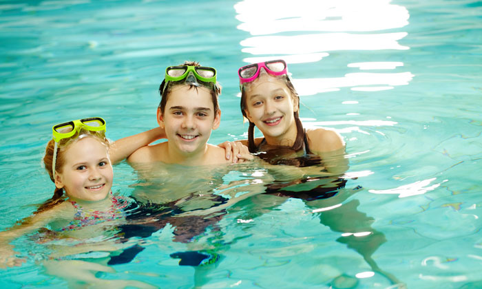 three kids having fun in pool water