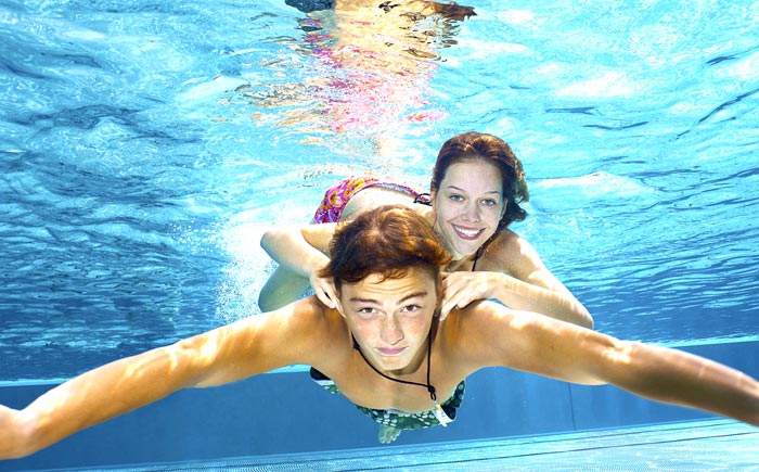 boyfriend and girlfriend happily swimming underwater