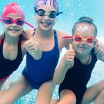 group of three underwater girls with goggles and bubbles